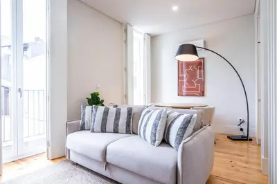 a living room with a couch and a lamp at Formosa Studio with Balcony by LovelyStay in Porto