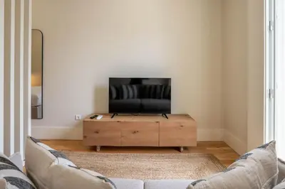 a living room with a couch and a flat screen tv at Formosa Studio with Balcony by LovelyStay in Porto