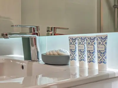 a sink with a faucet and a bowl of cookies at Brittos Avenue Apartment in Gaia in Vila Nova de Gaia