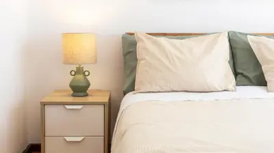a bedroom with a bed with a lamp on a night stand at Bright apartment next metro in Porto