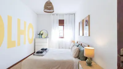 a white bedroom with a bed and a lamp at Bright apartment next metro in Porto