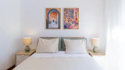 a bedroom with a white bed with two lamps at Bright apartment next metro in Porto
