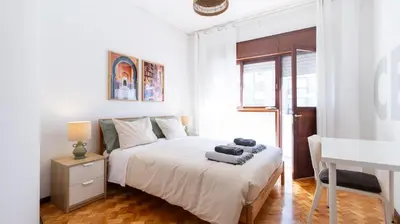 a white bedroom with a bed and a sink at Bright apartment next metro in Porto