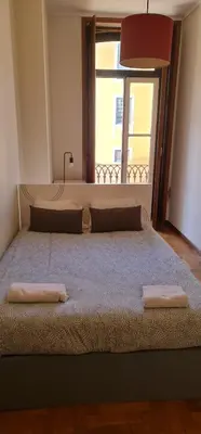a large bed in a room with a large window at Flores duplex in Porto