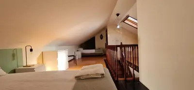 a bedroom with a bed and a staircase with a room at Flores duplex in Porto