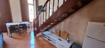 a living room with a staircase and a dining room table at Flores duplex in Porto