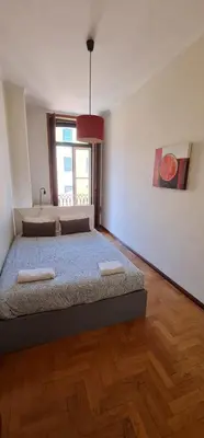 a bedroom with a large bed and a window at Flores duplex in Porto