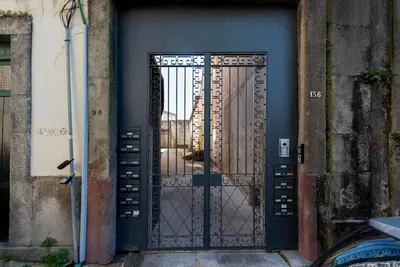 a black door with a metal gate on a building at Cedofeita Studio - Your Porto Escape in Porto
