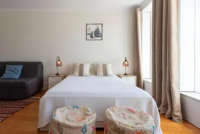 a bedroom with a bed with two chairs and a couch at Cedofeita Studio - Your Porto Escape in Porto