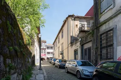 a street with cars parked on the side of a building at Cedofeita Studio - Your Porto Escape in Porto