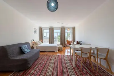 a living room with a bed and a couch and a table at Cedofeita Studio - Your Porto Escape in Porto