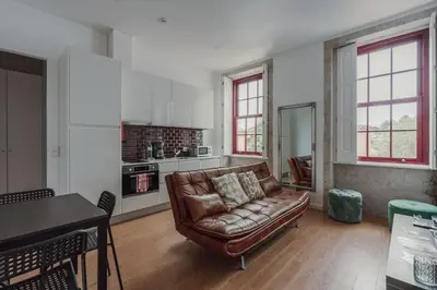 a bedroom with a white bed and a window at Mira Alfandega apartment in Porto