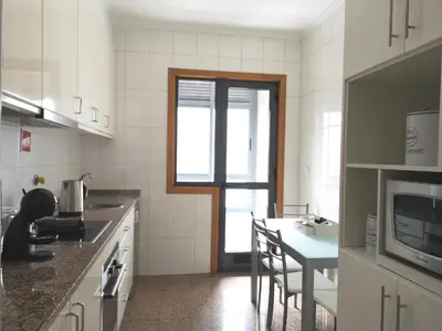 a kitchen with a counter and a table with chairs at Palácio Garden's House by LovelyStay in Porto