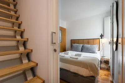 a small bedroom with a bed and a staircase at GuestReady - An urban retreat with river view in Porto