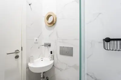 a white bathroom with a sink and a shower at GuestReady - An urban retreat with river view in Porto