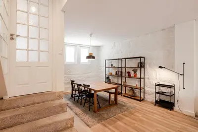 a dining room with a table and a white brick wall at VIVA Boavista Vintage House in Porto