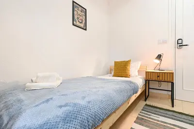 a bedroom with a bed and a lamp on a table at Casa Maya in Porto