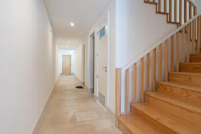 a hallway with wooden stairs in a home at Host Wise - Modern Urban Flat in Porto