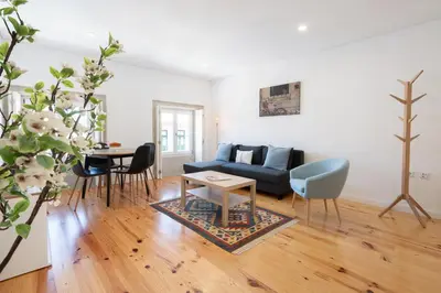a living room with a blue couch and a table at Host Wise - Modern Urban Flat in Porto