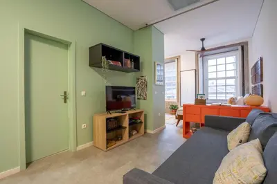 a living room with a blue couch and a television at Green Hideaway by LovelyStay in Porto
