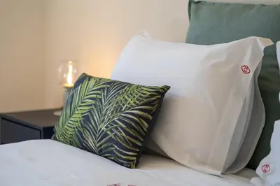 a group of pillows on a bed next to a table at HM - Oporto Studio Pool Oasis in Porto