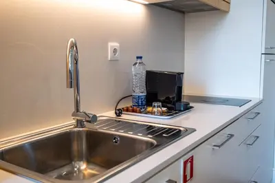 a kitchen with a sink and a bottle of water on the counter at HM - Oporto Studio Pool Oasis in Porto