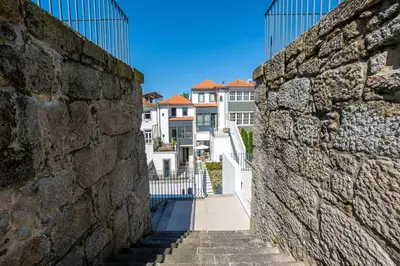 a stone wall and stairs with buildings in the background at HM - Oporto Studio Pool Oasis in Porto