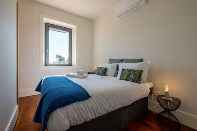 a bedroom with a large bed with a window at HM - Oporto Studio Pool Oasis in Porto