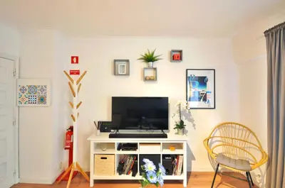 a living room with a tv on a white cabinet at Lips Friendship Shelter in Porto