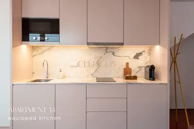 a kitchen with white cabinets and a sink at The Clérigos 46 in Porto