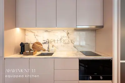 a kitchen with white cabinets and a black microwave at The Clérigos 46 in Porto