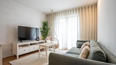 a living room with a couch and a tv at Serene 1BR Spot by LovelyStay in Porto