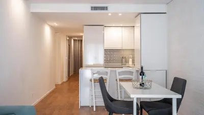a kitchen and dining room with a white table and chairs at Serene 1BR Spot by LovelyStay in Porto