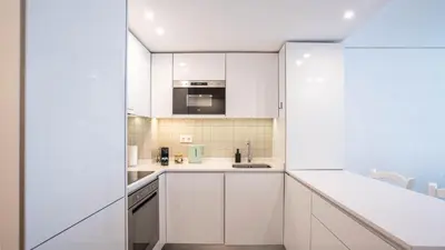 a kitchen with white cabinets and a sink at Serene 1BR Spot by LovelyStay in Porto
