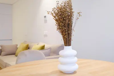 a white vase with flowers sitting on a table at Unique Antas Park in Porto