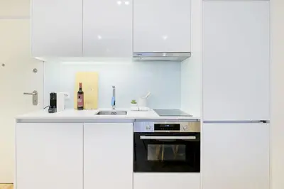 a white kitchen with a sink and a stove at Unique Antas Park in Porto