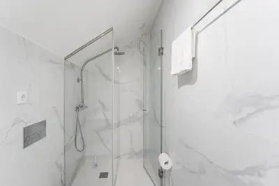 a white bathroom with a shower and a toilet at GuestReady - Lovely city retreat in Boavista in Porto
