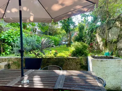 a wooden table with an umbrella on a patio at Hostel Alegria in Porto