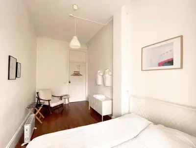 a white bedroom with a bed and a desk at Hostel Alegria in Porto