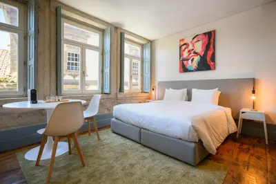 a bedroom with a large bed and a table and chairs at Live In Porto - Codeçal in Porto