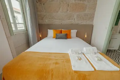 a bedroom with a large bed with towels on it at Downtown Suites by Vacationy in Porto