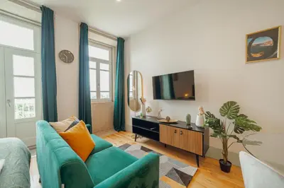a living room with a blue couch and a tv at Downtown Suites by Vacationy in Porto