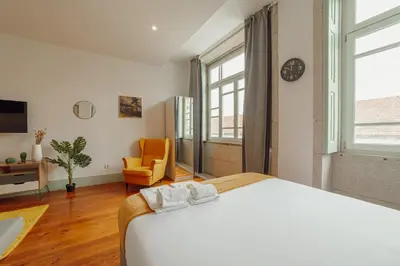 a bedroom with a bed and a chair and a clock at Downtown Suites by Vacationy in Porto