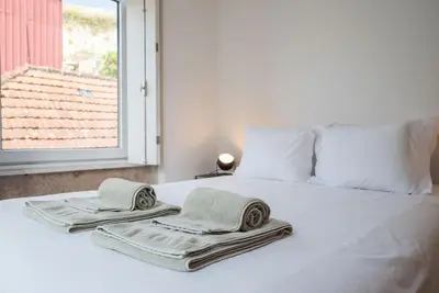 two towels on a bed with a window at Casa B in Porto