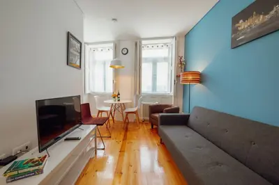 a living room with a couch and a television at Downtown Charming by Vacationy in Porto