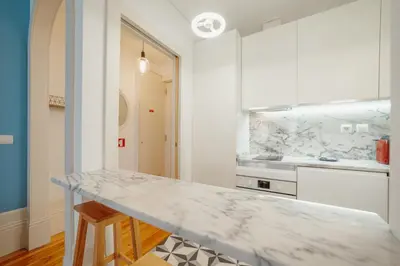 a white kitchen with a marble counter top in a room at Downtown Charming by Vacationy in Porto