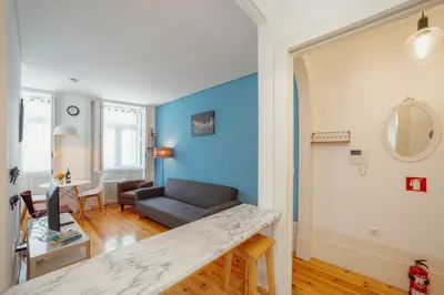 a living room with a blue accent wall at Downtown Charming by Vacationy in Porto