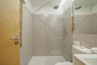 a bathroom with a shower with a toilet and a sink at Downtown Charming by Vacationy in Porto
