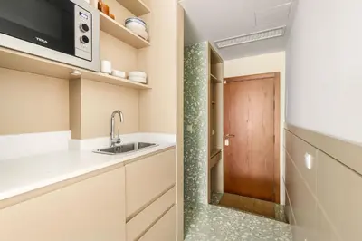a kitchen with a sink and a wooden door at Pelicano in Porto