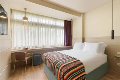 a hotel room with a bed and a window at Pelicano in Porto